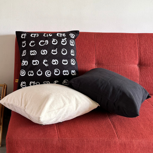 Black pillow with white patterns on a red sofa